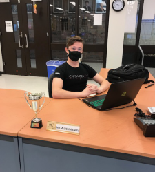 Student sits at office desk in front of laptop